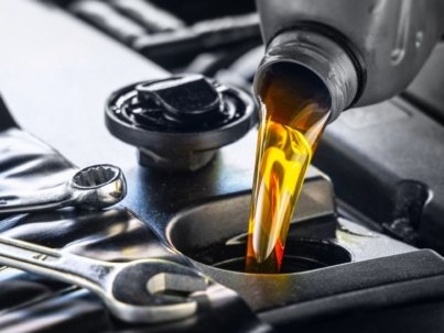 Pouring motor oil for motor vehicles from a gray bottle into the engine, ,  oil change,  auto repair shop, service,