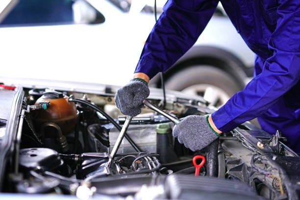 Automotive and car repair shops services by professional engine maintenance technicians. Auto mechanic using Socket wrench repair tools checking car in the Garage
